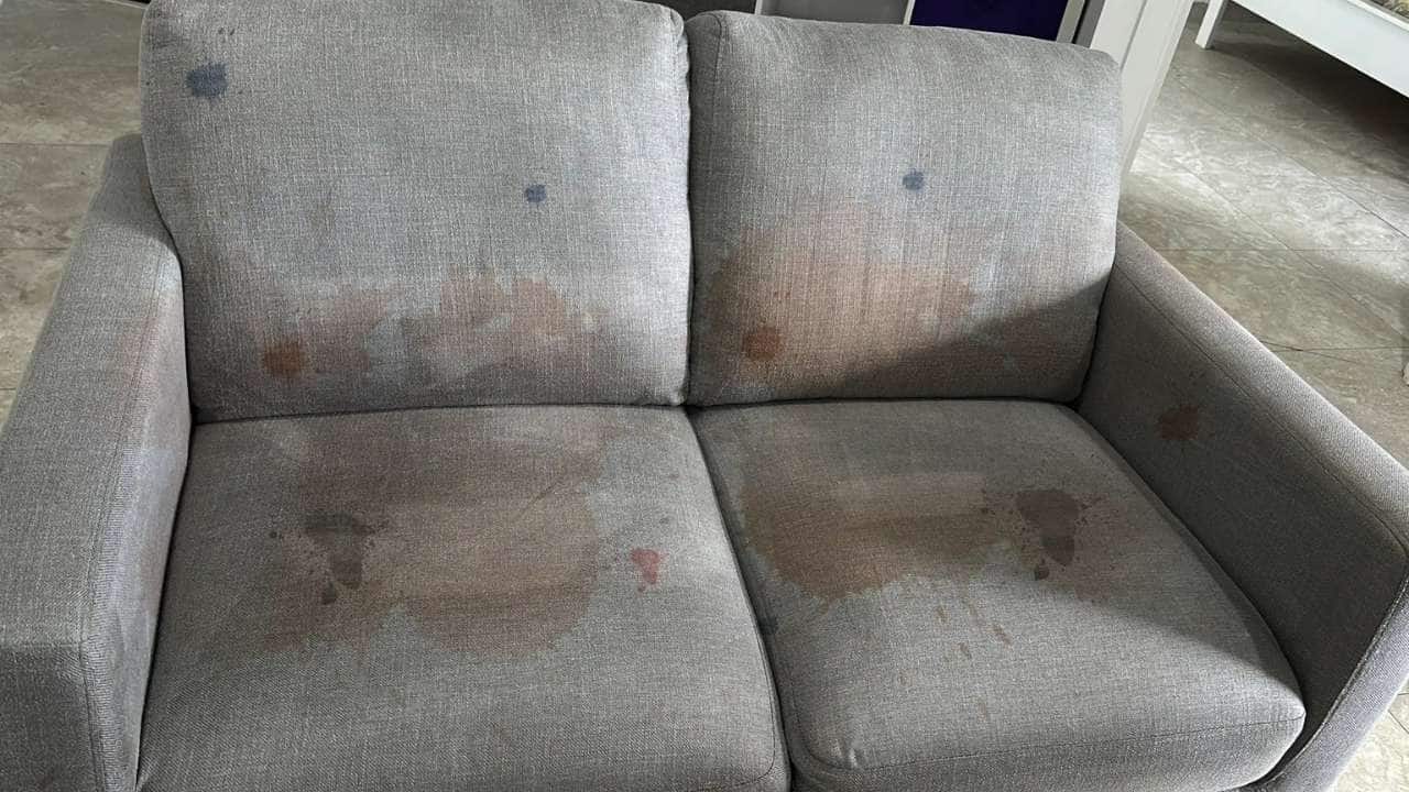 Couch with visible dirt and stains before professional couch cleaning
